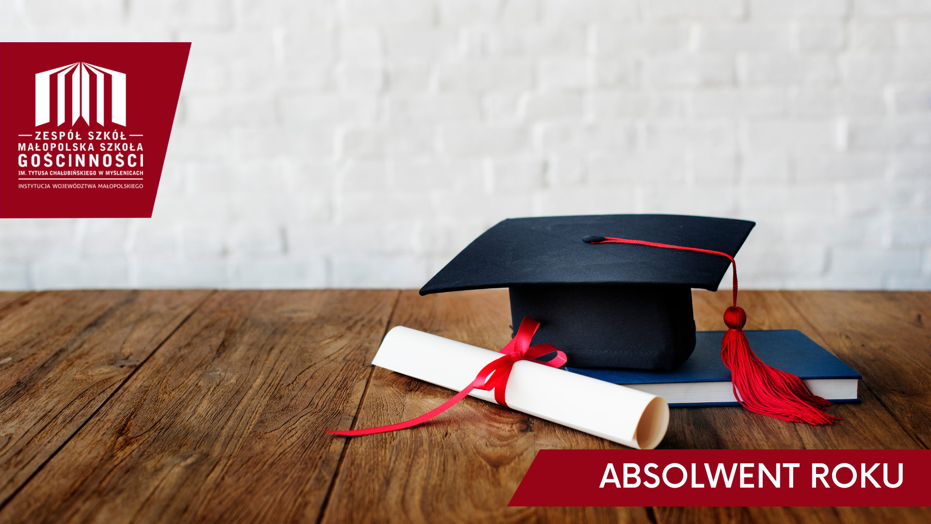 czapka absolwenta, książka i dyplom przewiązany czerwoną wstążką, położone na drewnianym stole