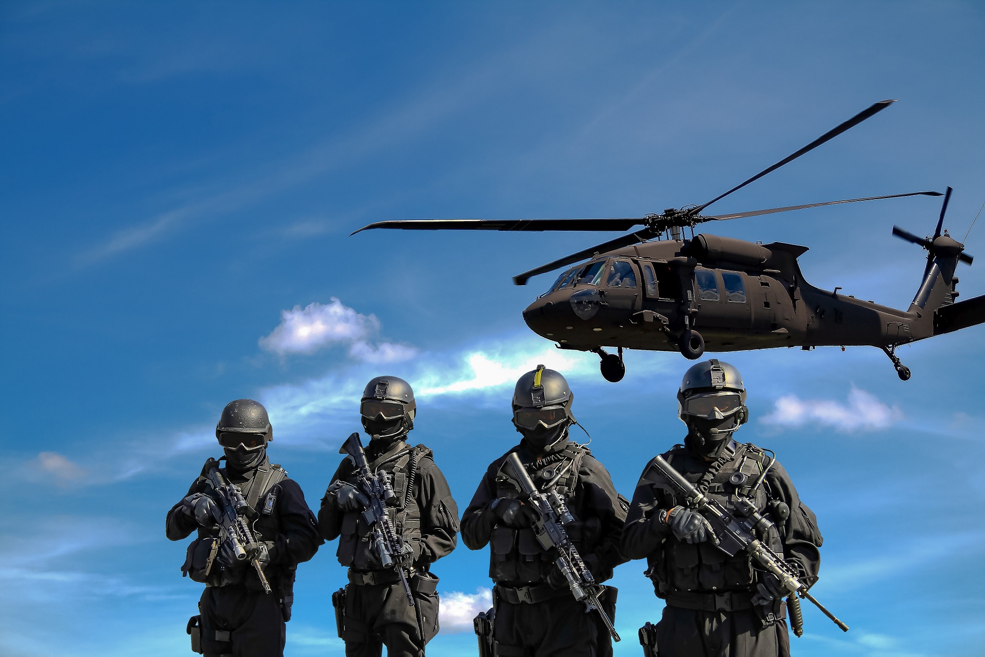 żołnierze trzymający karabiny i helikopter wojskowy