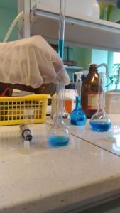 na zdjęciu laboratorium i probówki z niebieskim płynem