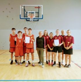 na zdjęciu grupa dziewcząt i chłopców, reprezentacja szkoły w powiatowych zawodach koszykówki wraz z opiekunem